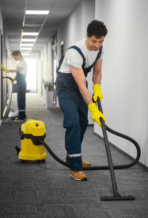 Professional commercial carpet cleaning in a modern office corridor with extraction equipment